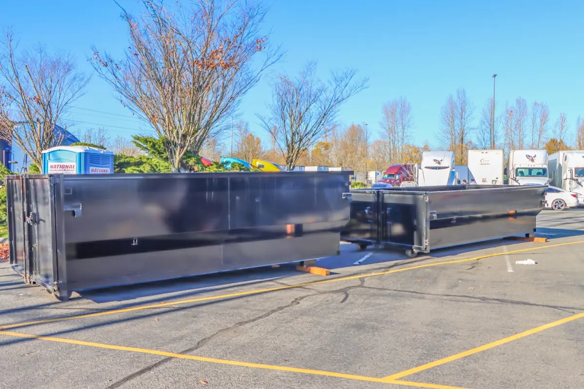 Professional dumpster rental service with roll-off container on residential driveway in Plainfield